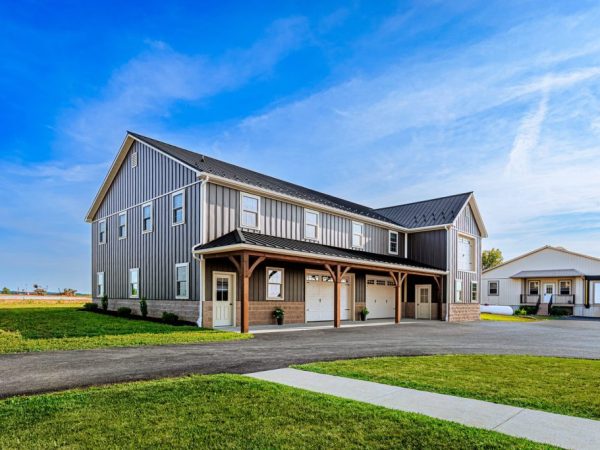 Front view of a commercial garage with wood posts, covered parking, and three garage doors.