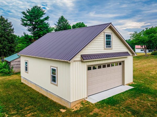 Angled view of a two-story beige garage with a brown metal roof and vinyl siding.