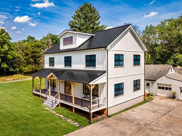 Aerial view of a new construction home beside an older detached garage.