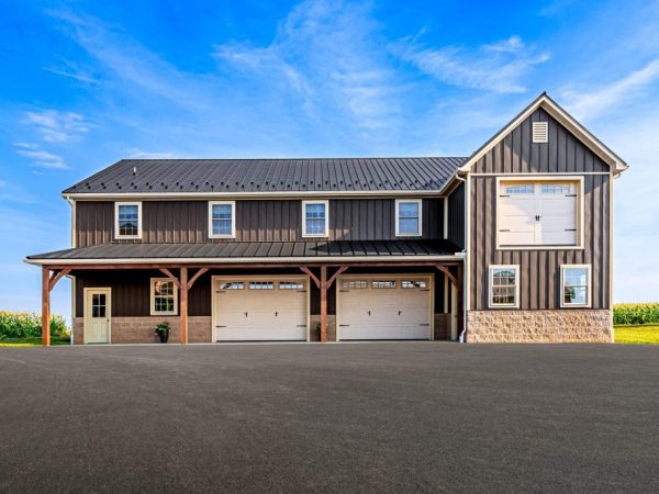 Straight-on view of commercial garage with large center garage door and upstairs barn door.