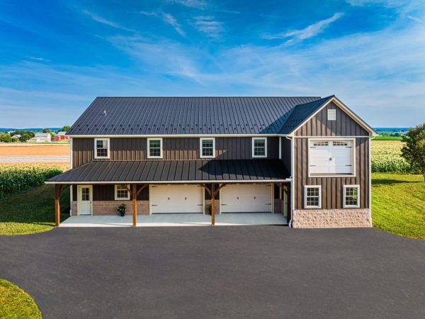 Aerial view of commercial garage with black roof and three garage doors under a covered entry.