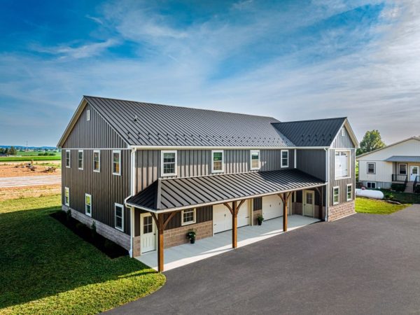 Two-story garage with vertical metal siding, black roof, and covered front porch with four entrances.